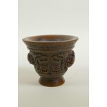 A Chinese faux horn libation cup with two carved handles in the form of a climbing kylin,