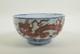 A Chinese blue and white porcelain bowl of lobed form, decorated with iron red dragons to exterior