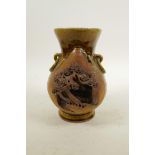 A Chinese treacle glazed pottery vase with two lug handles, decorated with a village scene, 7" high