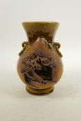 A Chinese treacle glazed pottery vase with two lug handles, decorated with a village scene, 7" high