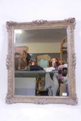 A bevelled glass wall mirror in a giltwood and composition gallery frame, 27" x 32"