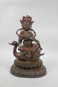 A Tibetan painted, gilt and distressed bronze of Buddha seated on a duck's back, 11½" high