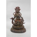 A Tibetan painted, gilt and distressed bronze of Buddha seated on a duck's back, 11½" high