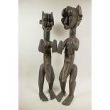 A pair of African carved wood ritual figures of a male and female, 22" high