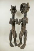 A pair of African carved wood ritual figures of a male and female, 22" high