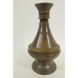 An antique bronze vase with slender neck and whorled and ring turned decoration, possibly Persian,
