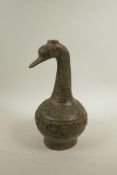 A Chinese bronze vessel, the neck in the form of a phoenix, the body with raised archaic decoration,