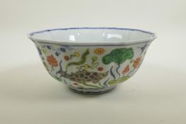 A Chinese wucai porcelain bowl of lobed form decorated with carp in a lotus pond, 6 character mark