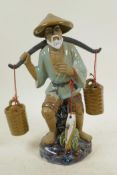 A large Chinese, Shiwan style, mud men figure of a fisherman with his baskets and catch, 11½" high