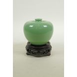 A Chinese apple green glazed porcelain vase, on a carved hardwood stand, 4½" high