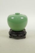 A Chinese apple green glazed porcelain vase, on a carved hardwood stand, 4½" high