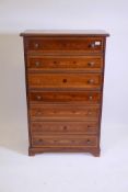 A Continental style inlaid walnut semainier with seven moulded front drawers, raised on bracket