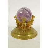 A fluorspar crystal ball on a triform ormolu stand in the form of dogs, 4" high