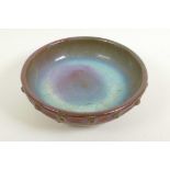 A Chinese Song style porcelain shallow bowl with studded decoration and brown/green glaze on three