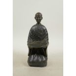 A Chinese bronze card tray in the form of a kneeling figure, 9" high