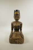 An Indian carved and painted wooden seated figure, 13½" high