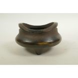 A Chinese bronze censer with phoenix eye handles and tripod supports, impressed two character mark