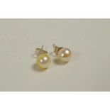 A pair of freshwater pearl stud earrings, on white metal posts