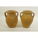 A pair of continental terracotta two handled jars, 8" high