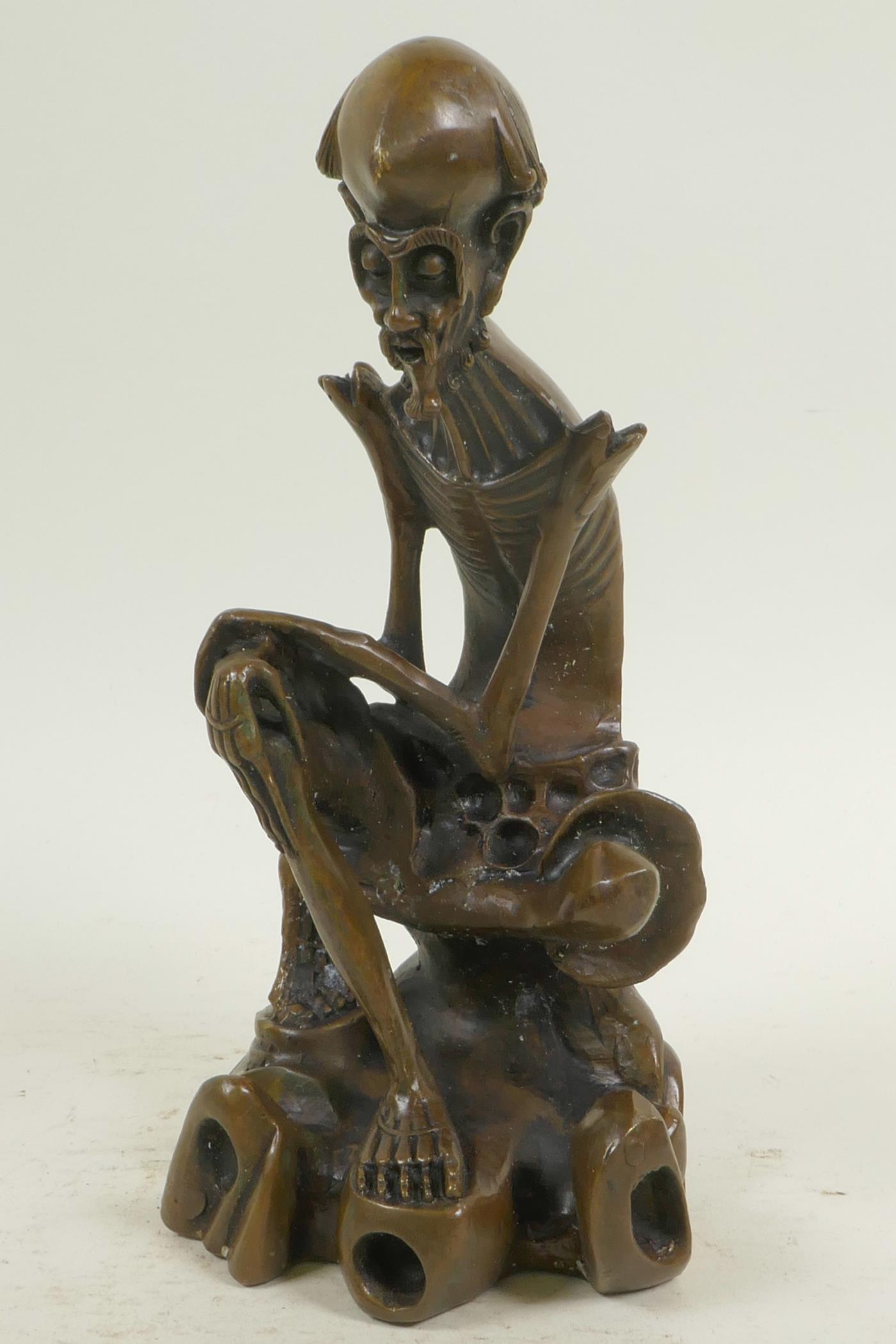 A bronze figure of a skeletal man, 8½" high