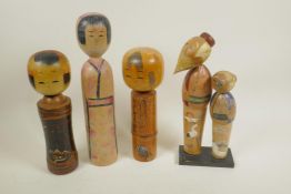 Four Japanese painted wood Kokeshi dolls, largest 12" high