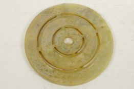 A Chinese hardstone pi disc carved as three concentric rings with dimpled decoration, 4¾" diameter