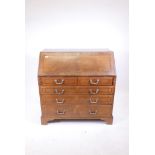 An early C19th walnut bureau with crossbanded inlay decoration, fitted interior, and two short