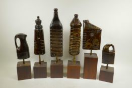 A collection of four carved and lacquered wood bottle maquettes mounted on display plinths,