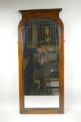 A C19th wall mirror in mahogany, with decorative feather banding on the borders and a simple