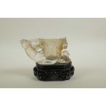 A Chinese moulded glass libation cup with pierced dragon, kylin and phoenix decoration, on an