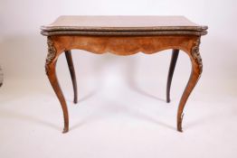 A C19th walnut serpentine fronted card table, with inlaid decoration, and brass mounts, the fold