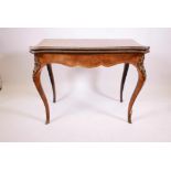 A C19th walnut serpentine fronted card table, with inlaid decoration, and brass mounts, the fold