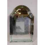 A 1930s Art Deco cut and bevelled glass wall mirror with shaped top and green glass decoration, some