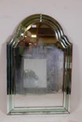 A 1930s Art Deco cut and bevelled glass wall mirror with shaped top and green glass decoration, some