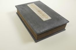A Chinese hardwood and material bound book containing white jade tablets with chased and gilt