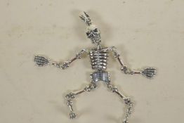 A silver articulated skeleton pendant, 2½" long