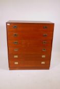 A mid C20th teak chest, comprising six drawers with military style handles, raised on a plinth base,