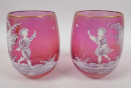 A pair of cranberry glass tumblers with Mary Gregory style decoration of young children and a