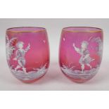 A pair of cranberry glass tumblers with Mary Gregory style decoration of young children and a