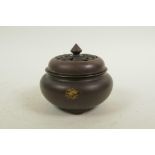 A Chinese bronze censer and cover on tripod supports, with gilt splash patina, impressed seal mark
