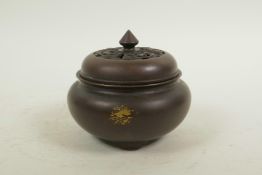 A Chinese bronze censer and cover on tripod supports, with gilt splash patina, impressed seal mark