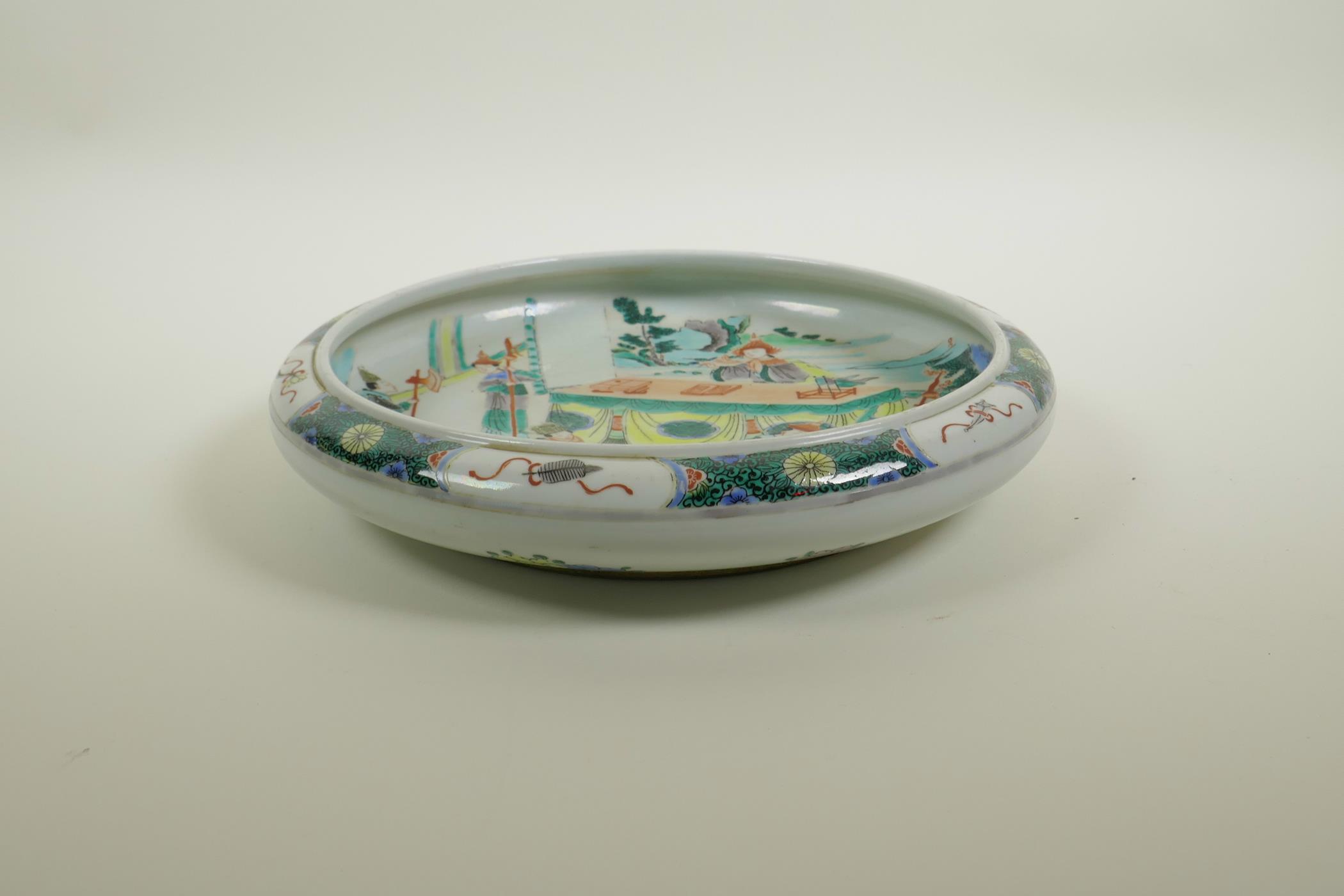 A Chinese famille verte porcelain dish with a rolled rim, decorated with figures in an interior - Image 2 of 4