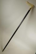 A carved bone handled walking stick with a brass cuff, 36½" long