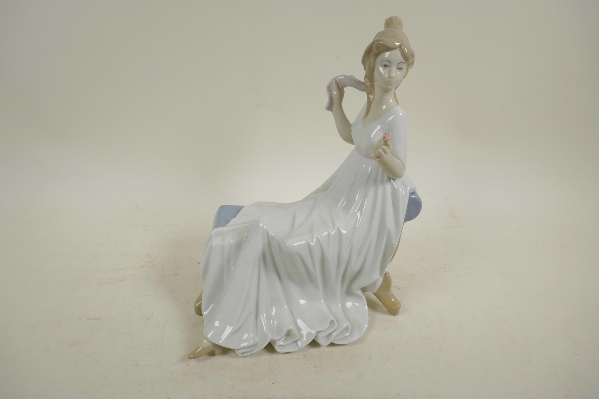 A Spanish D'Art. SA porcelain figure of a girl in a long dress seated on a chaise, 10½" high - Image 2 of 4