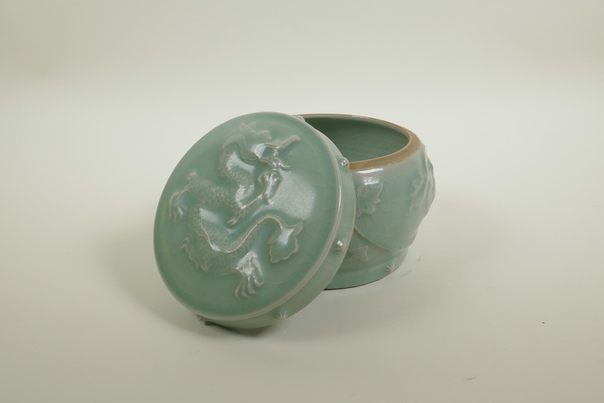 A Chinese celadon crackle glazed porcelain pot and cover with raised underglaze dragon and lotus - Image 2 of 5