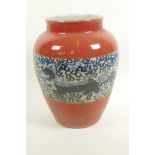 A Chinese porcelain baluster vase with red glaze and blue and white band, decorated with dragons