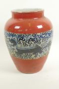 A Chinese porcelain baluster vase with red glaze and blue and white band, decorated with dragons