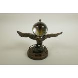 A brass and glass ball desk clock mounted on the back of an eagle, 7" wide, 5½" high