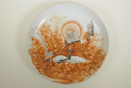 A Chinese polychrome porcelain charger decorated with a Lohan in red robes with excessively long