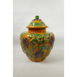 A large Chinese Sancai glazed pottery jar and cover with raised scrolling lotus flower decoration,